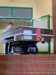 Klimaanlage wird mit Treppenraupe transportiert