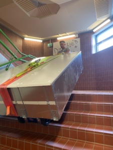 Belüftungsanlage 550Kg wird mithilfe einer Treppenraupe über die Treppe transportiert